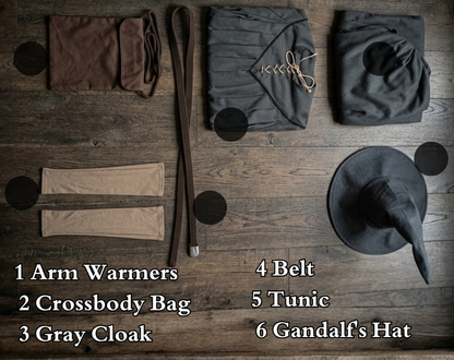 Gandalf the Grey 6 piece cosplay set flat lay on wood surface showing all included items labeled arm warmers crossbody bag gray cloak belt tunic and hat