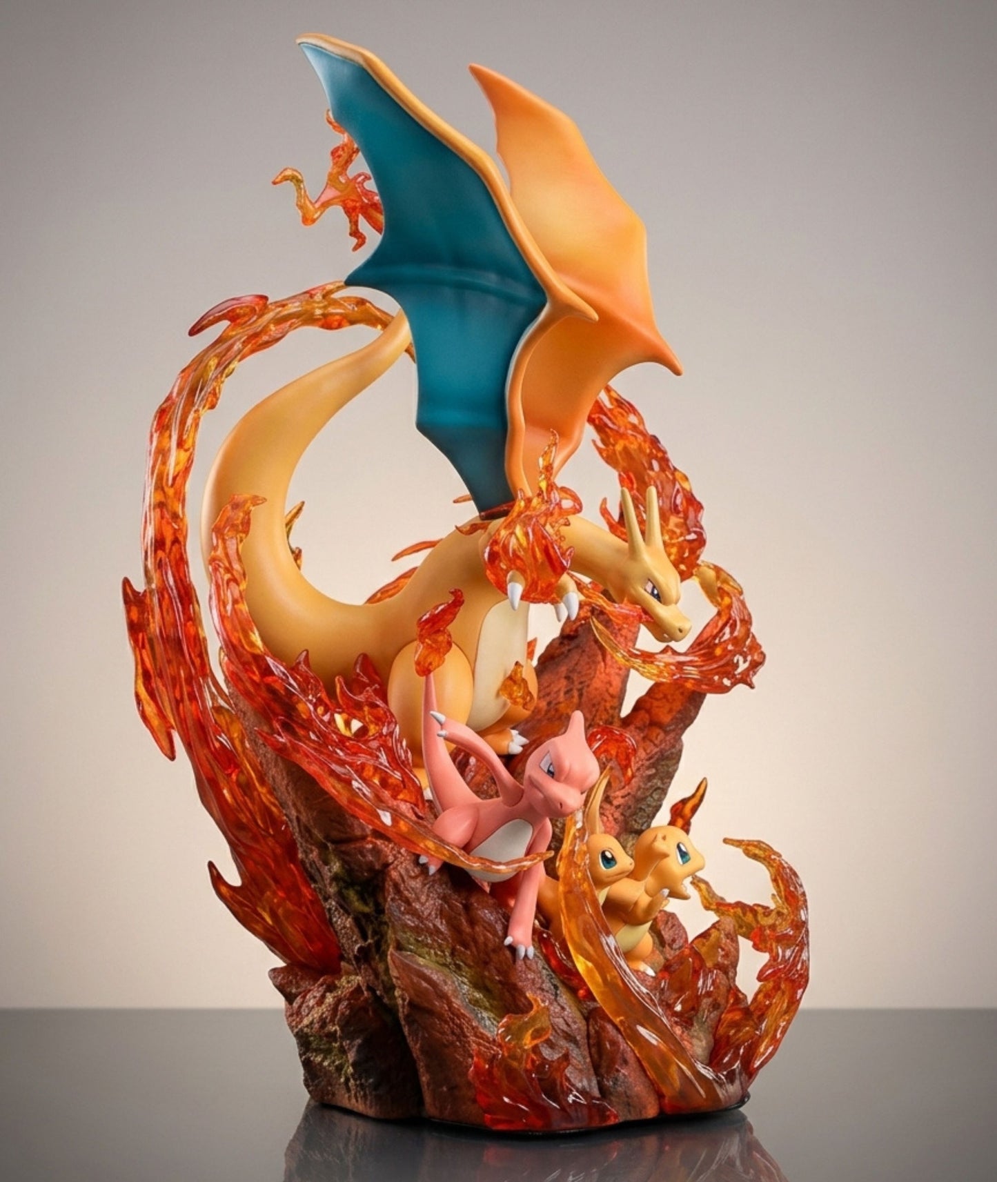 A detailed collectible figurine of Charizard,小火龙, and 小火焰龙 posed on a rocky base with flowing orange and red flames, set against a neutral gray studio background.