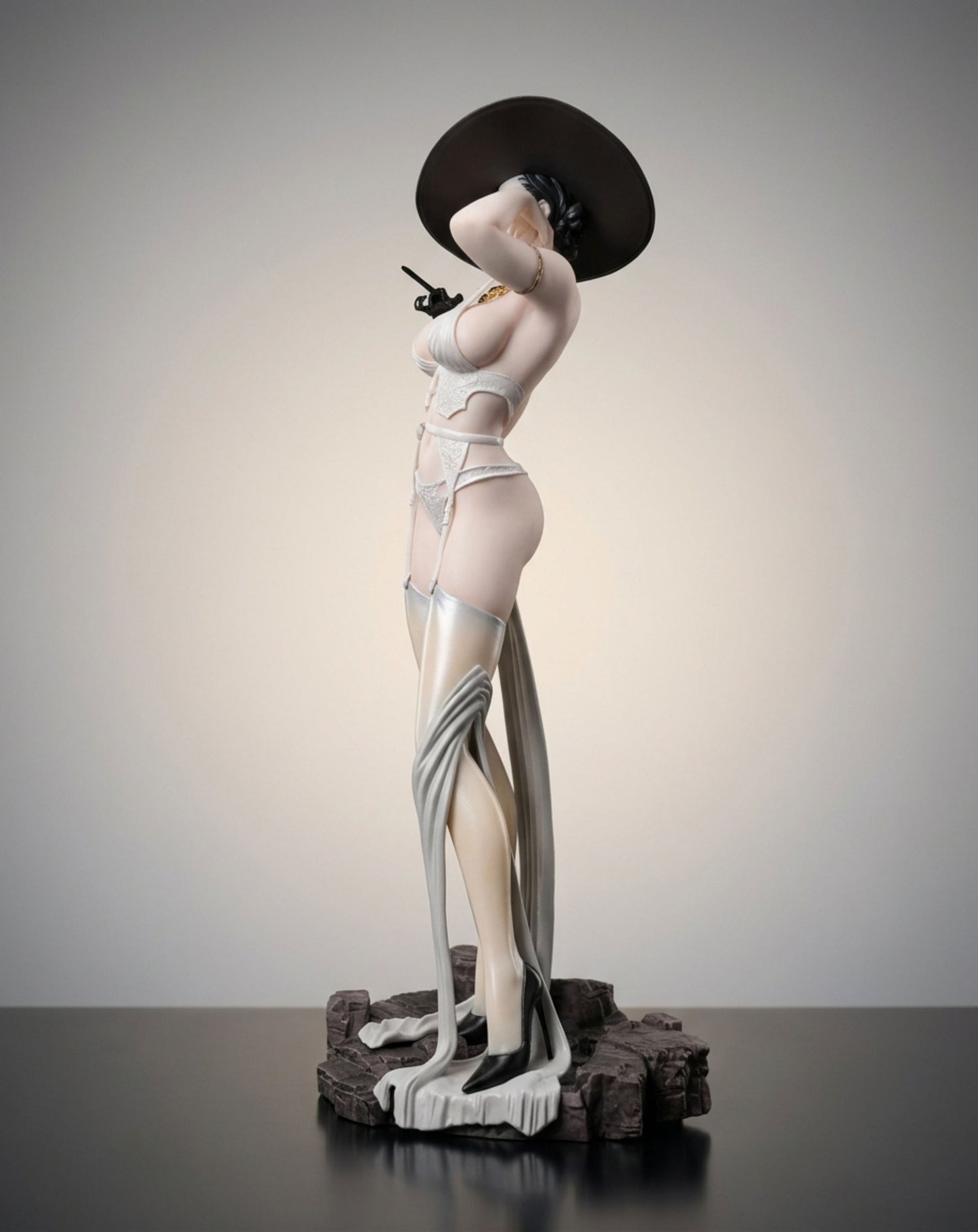 A stylized Lady Dimitrescu figurine in a pale pink and white lingerie outfit with a large black hat, posed on a dark textured base against a neutral studio background.