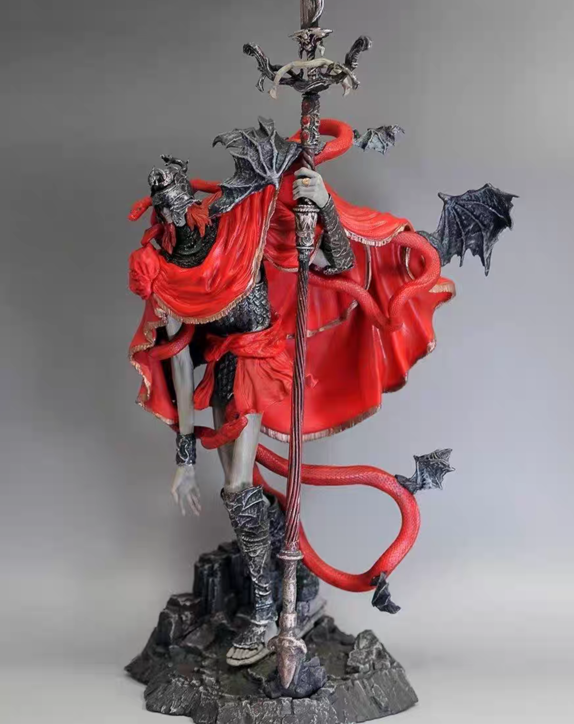 Side view of the Messmer the Impaler statue highlighting the serpent tail motif and bat-winged shoulder detail