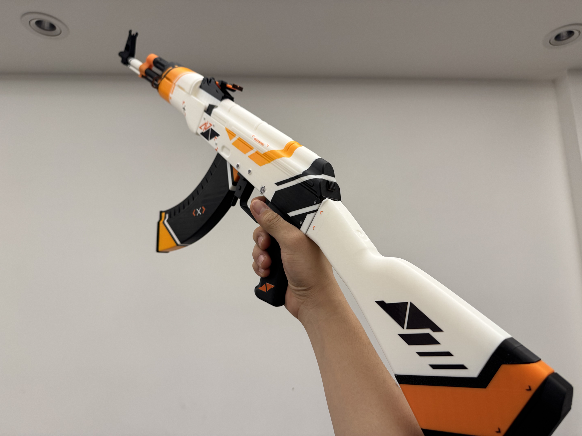 CS2 Asiimov AK-47 life size replica held in hands — 90cm fan made collectible prop, size reference photo, dark background
