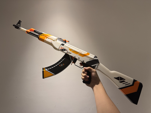Real life size CS2 Asiimov AK-47 replica on display stand — 1:1 scale plastic collectible, dark studio background, full length side view