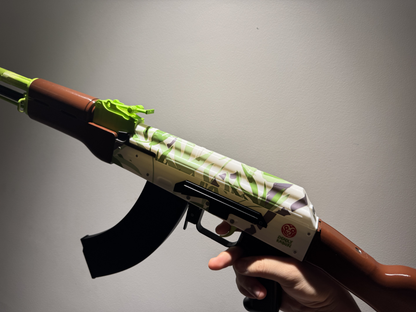 Real life size AK-47 Hydroponic CS2 skin replica — green and teal graffiti pattern detail shot, display stand, studio lighting
