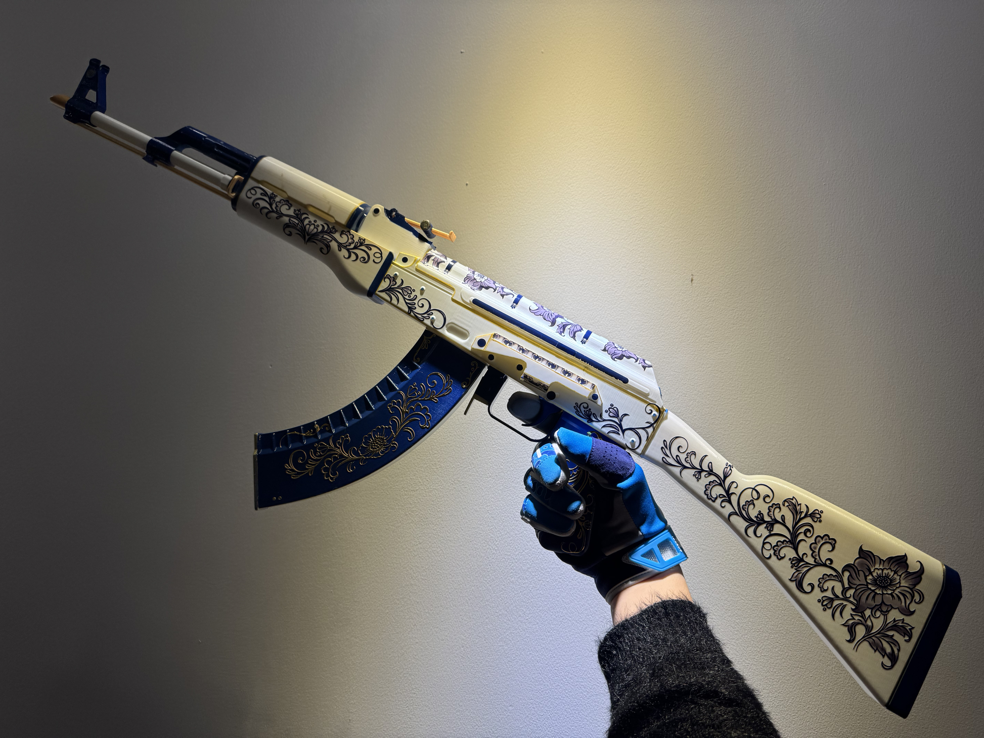 Real life size AK-47 Inheritance CS2 skin replica — wood grain and gold engraving detail shot, display stand, studio lighting