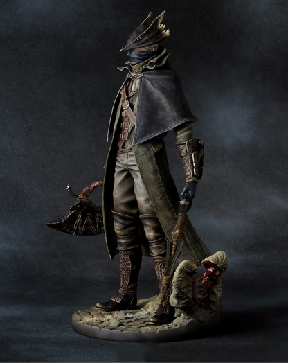 A detailed collectible figurine of a character from Bloodborne, The Hunter on a rocky base against a dark studio background.