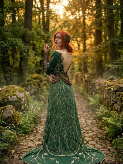 Triss Merigold green dress full body rear view showing gold embroidery detail and flowing train on forest path at sunset