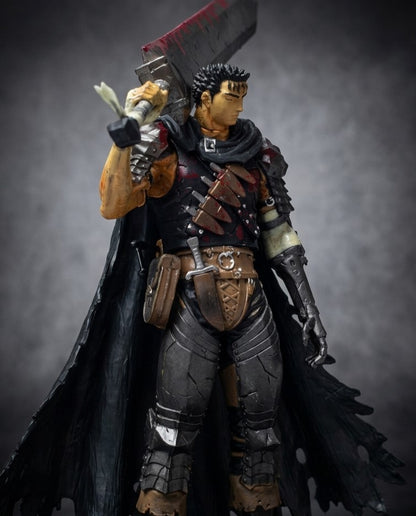 Berserk Guts collectible statue at a three-quarter angle, showing the battle-worn armor, tattered cloak and massive raised greatsword