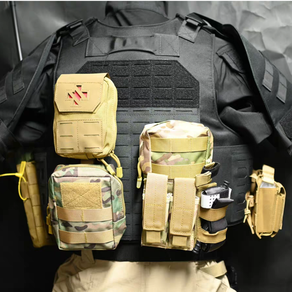 Tan and camouflage tactical pouches mounted on Konig cosplay vest, medical pouch and utility holders, front view