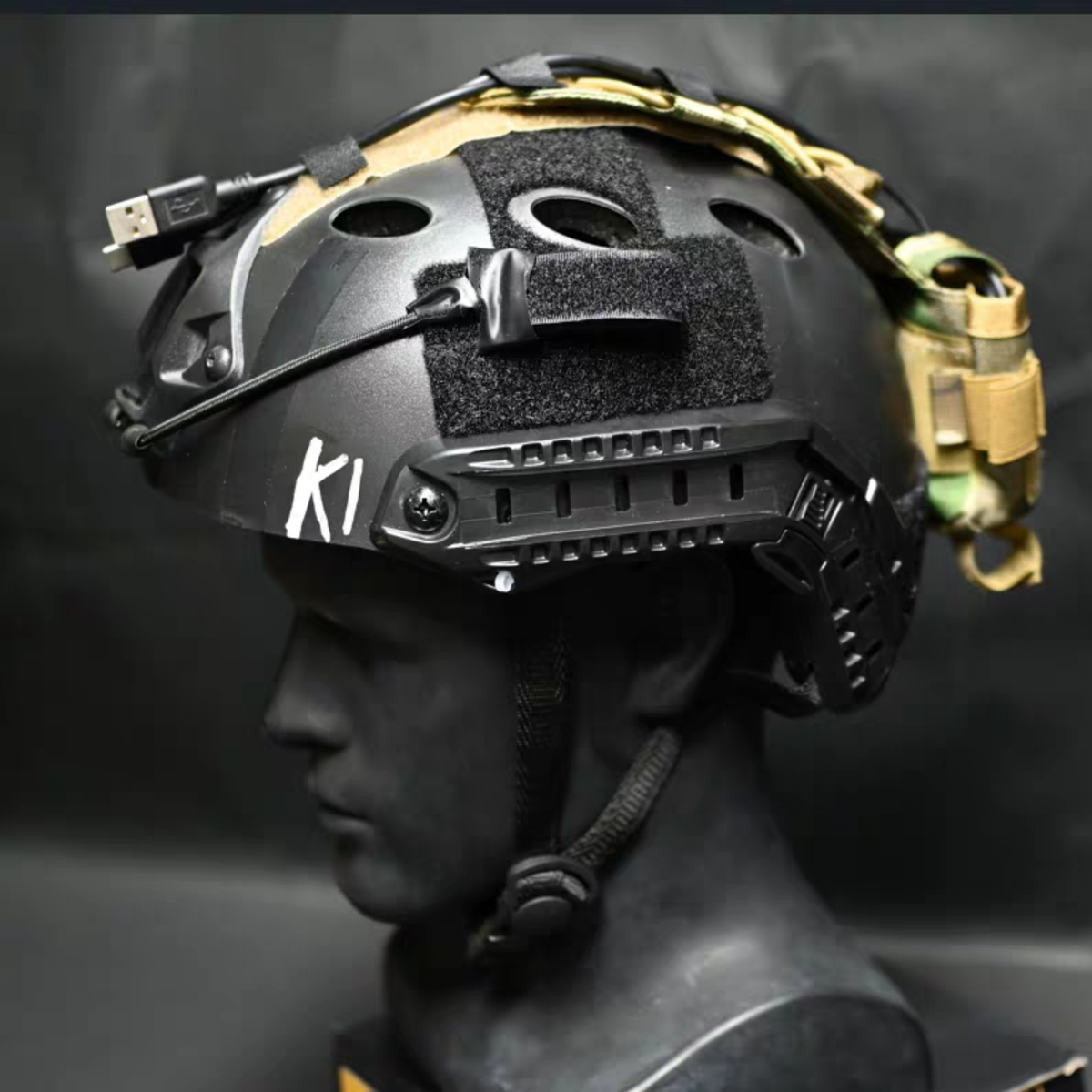 Konig tactical cosplay helmet side profile with velcro patch panel, rails and tan accessory strap detail