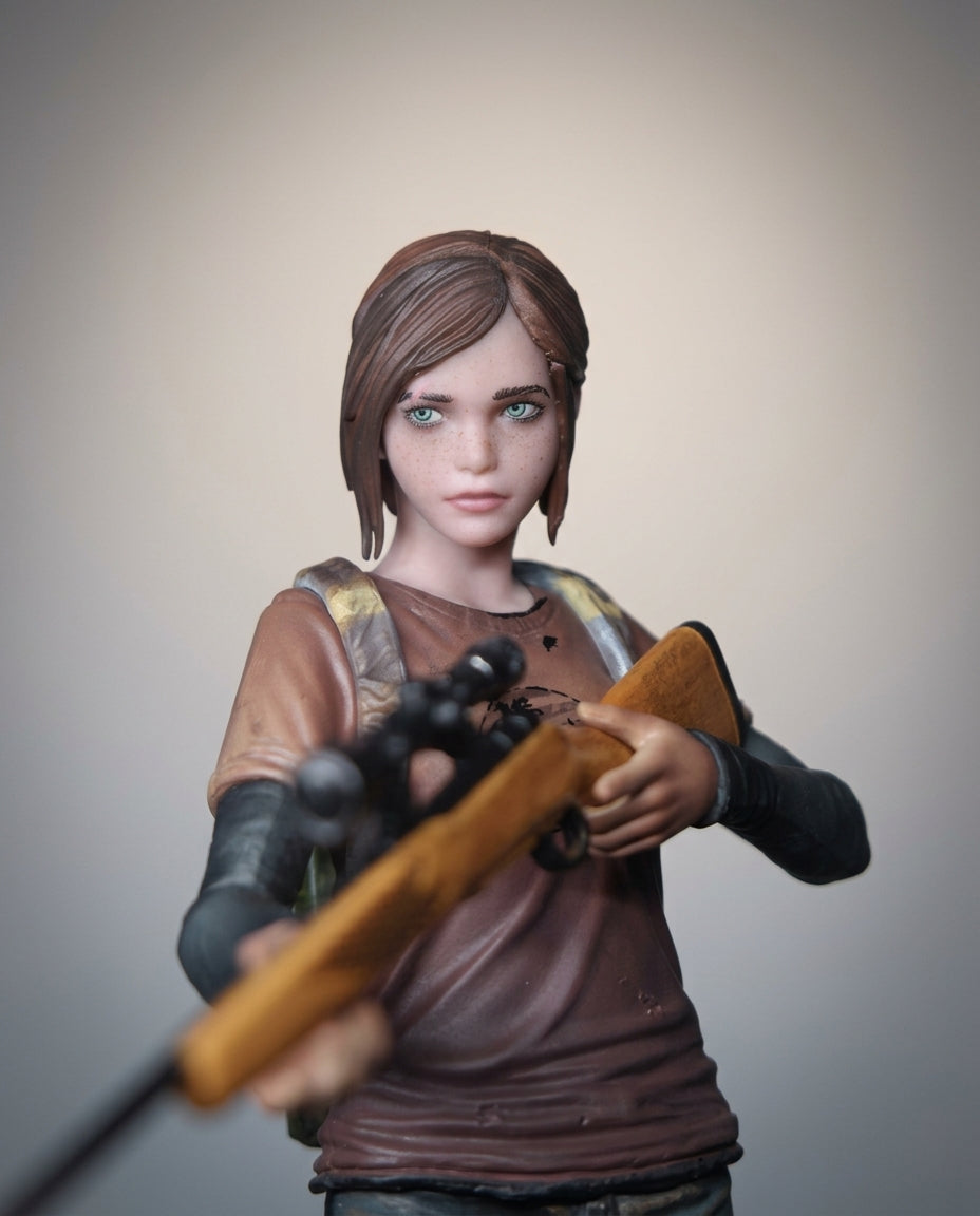 Close-up of the The Last of Us Ellie figure's face and rifle, detail shot of the sculpt and paintwork