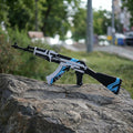 Life size 87cm AK47 Vulcan CS2 replica held in hand outdoors — white and blue geometric skin detail, grass background, front angle view