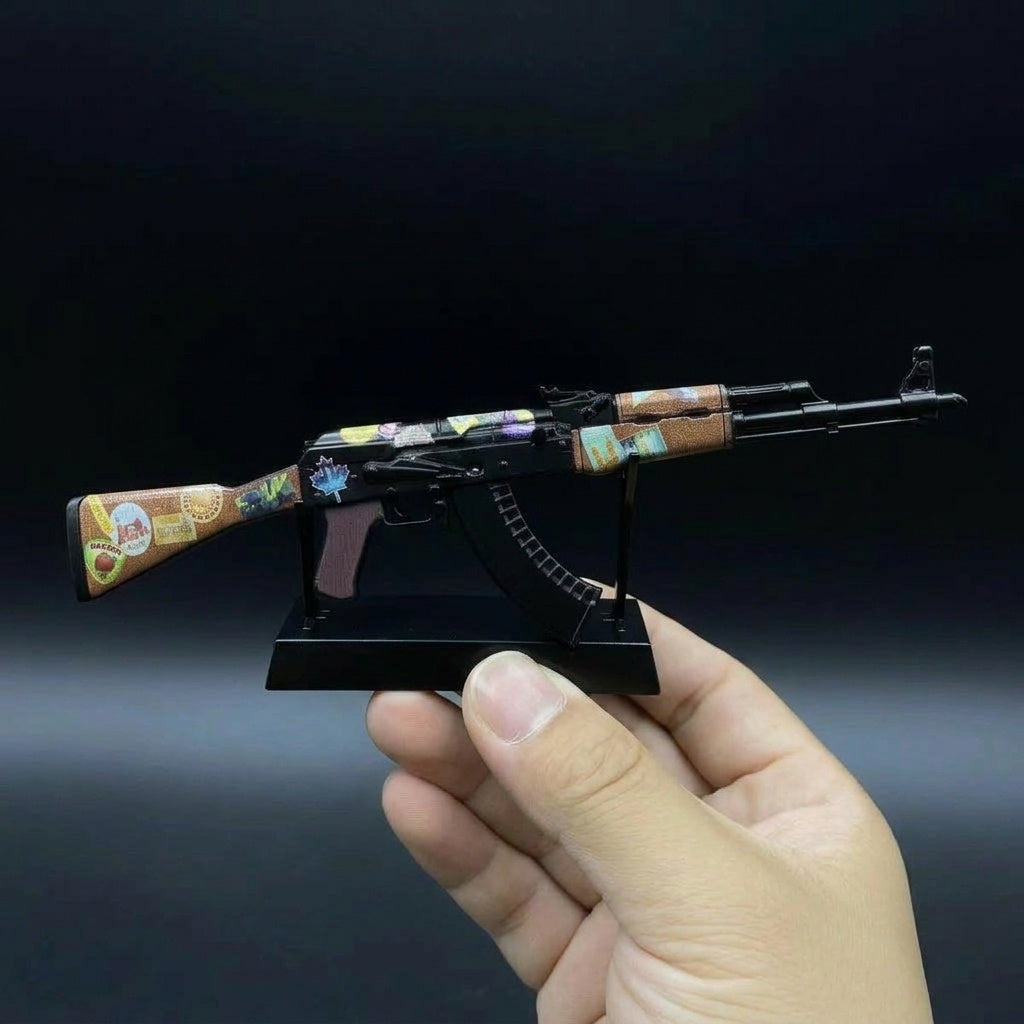 Close-up hand holding CS2 AK47 Jet Set mini replica from below, showcasing dark body and colorful sticker skin details