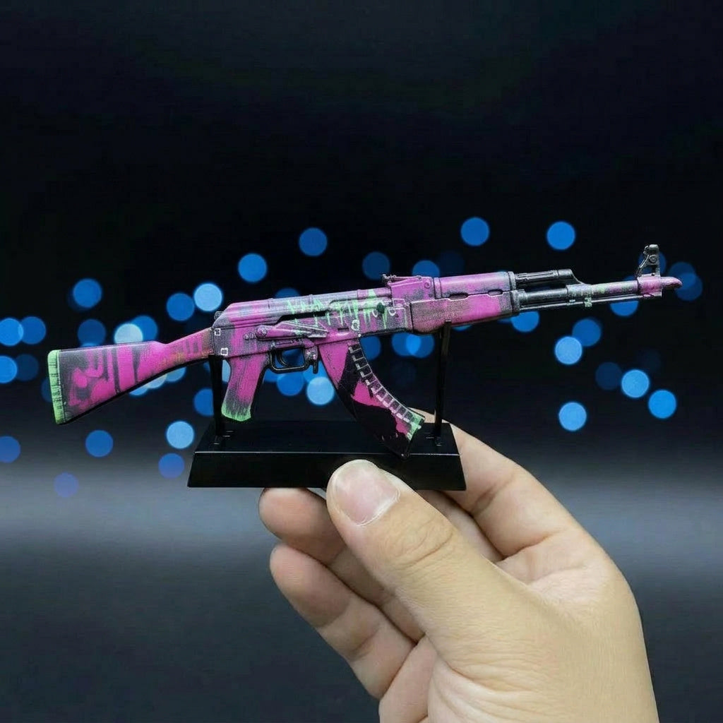 Hand holding CS2 AK47 Neon Revolution mini replica from below, showing bold purple and pink skin detail up close