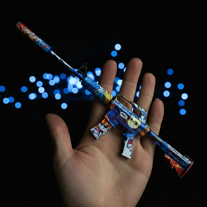 Hand holding Mini M4A1-S Player Two CS2 skin replica — small metal collectible desk piece, black background, front angle view