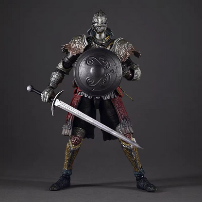 A highly detailed Raging Wolf Elden Ring warrior action figure or collectible statue, dressed in dark metallic armor with red fabric accents and holding a large round shield and a long sword, posed against a dark gray studio background.