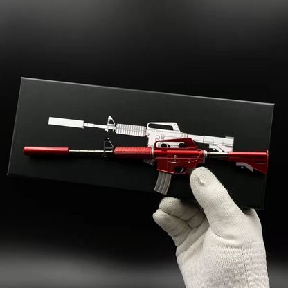 Hand holding Mini M4A1-S Hot Rod CS2 skin replica — small metal collectible desk piece, black background, front angle view