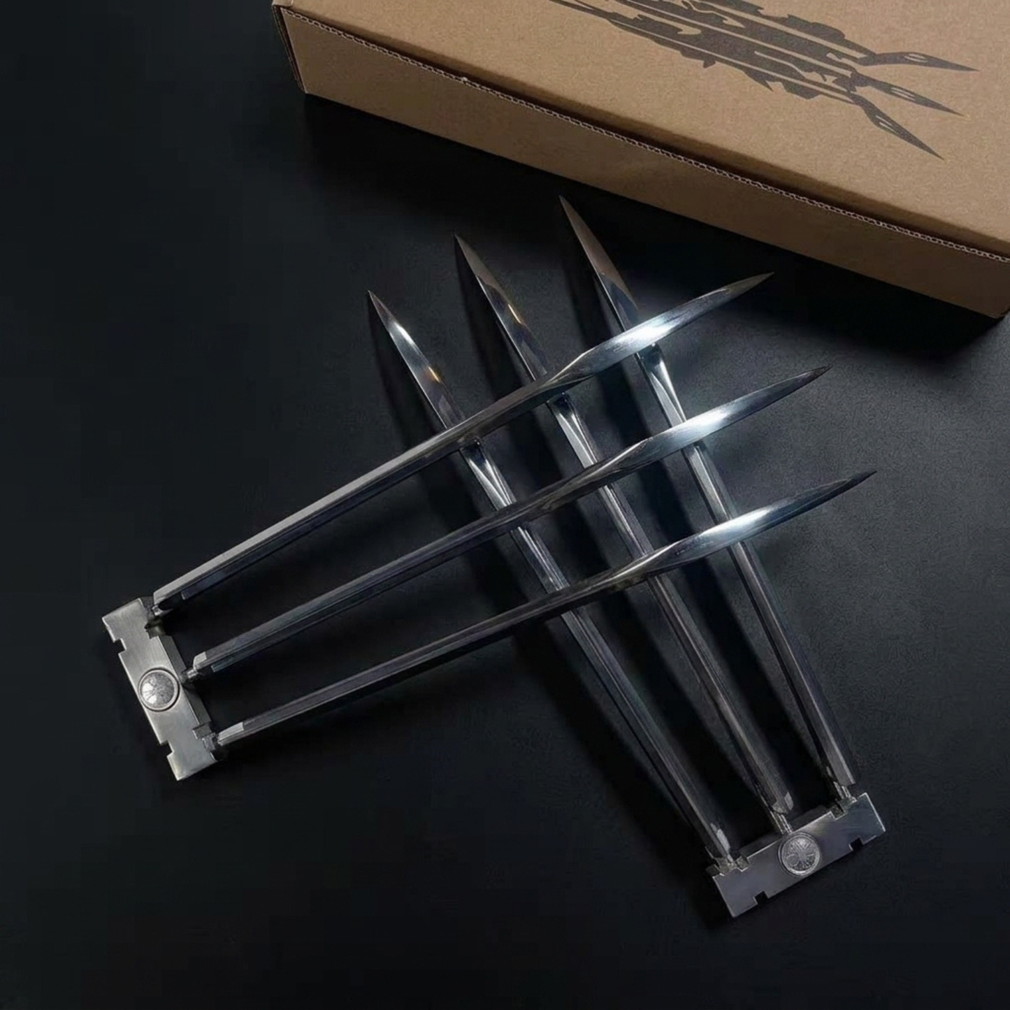 X-Men Wolverine claws metallic claw-like blades arranged on a dark surface, with a brown cardboard box partially visible in the background. Gift For Wolverine Fans, Collectible cosplay display acessories